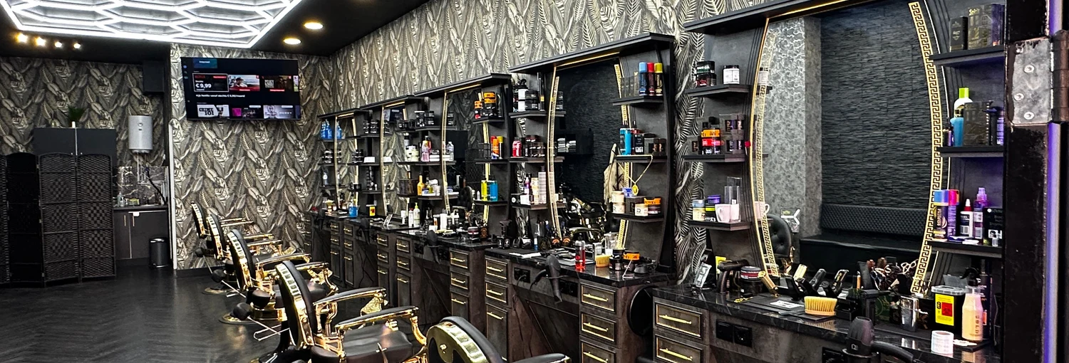 The salon with gold barber chairs and geometric ceiling lights